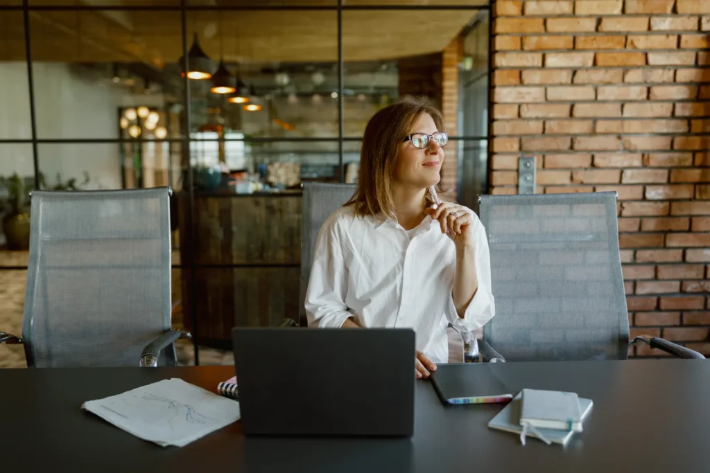 Monólogo interno em inglês: mulher pensa em frases curtas diante do laptop na sala de reunião