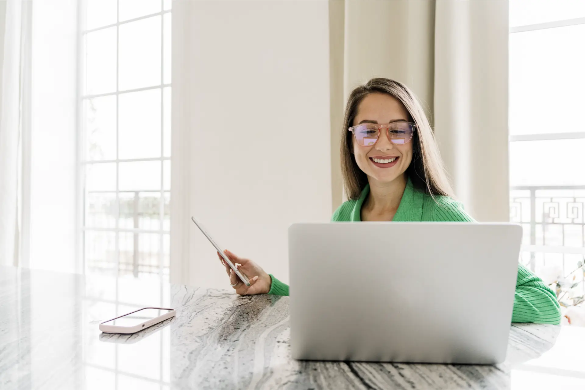 Estudar inglês com IA: mulher de óculos pratica no laptop e no tablet em casa