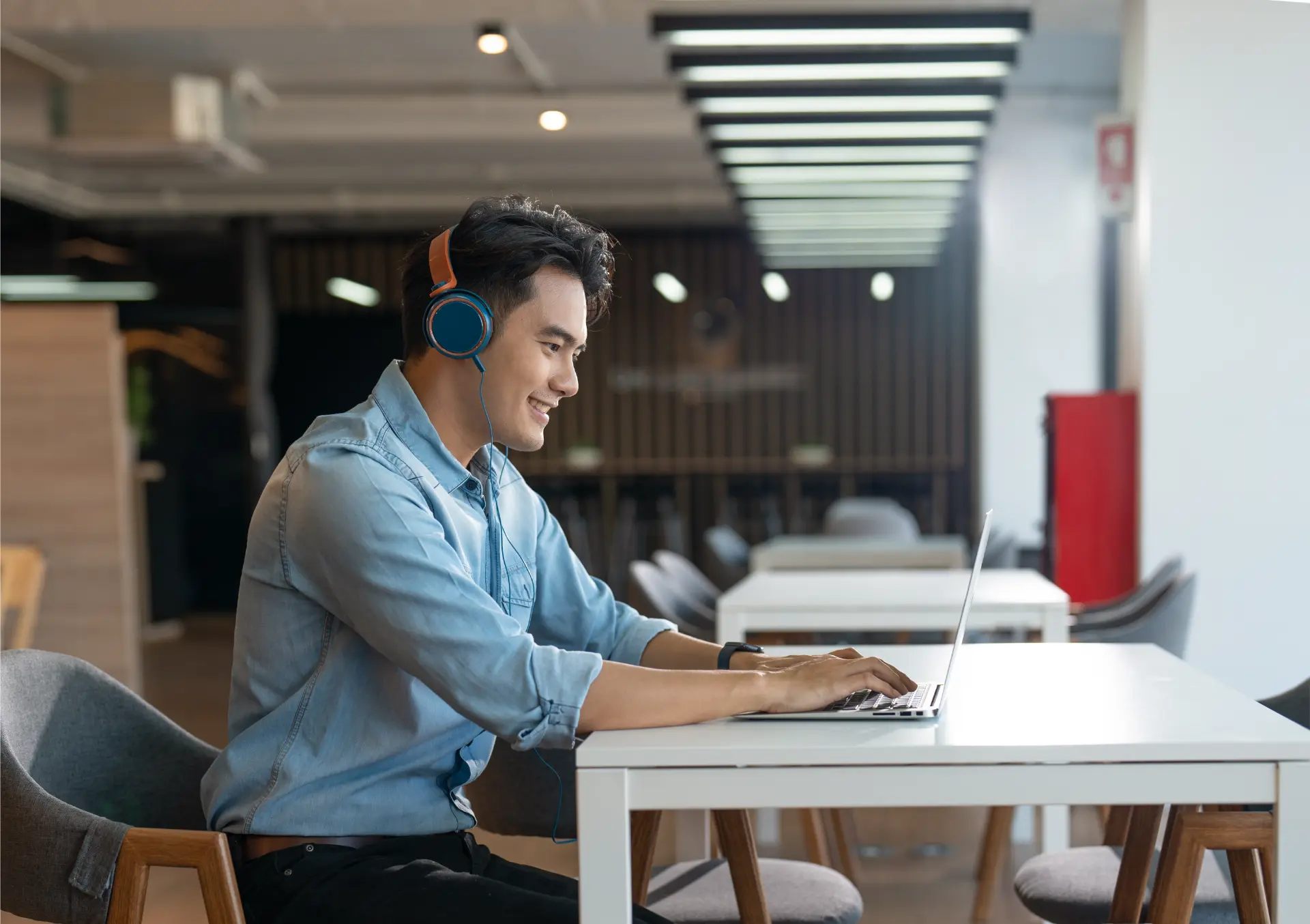 Músicas para treinar listening em inglês: jovem de fones acompanha a letra da faixa no laptop