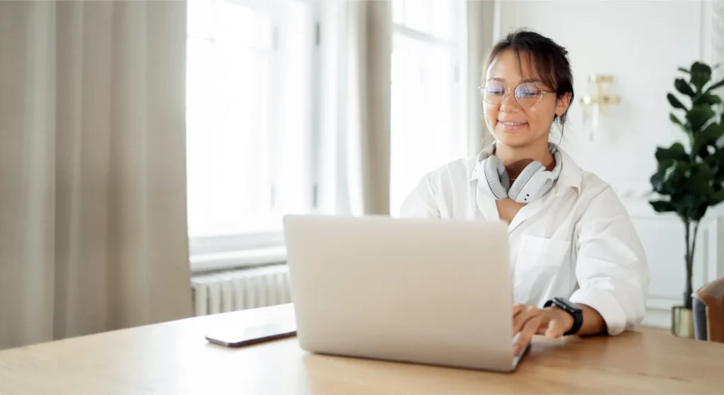 Profissional com fones em home office consumindo conteúdo em inglês