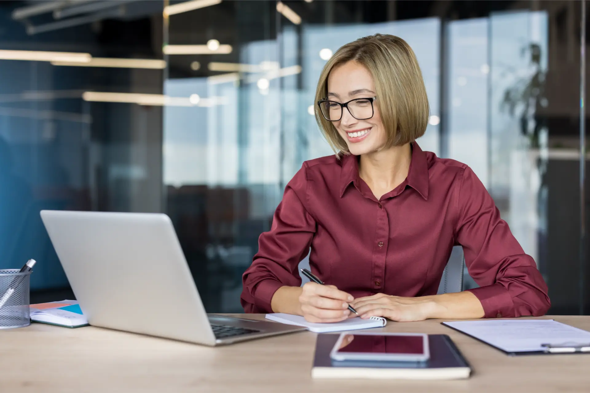 Profissional estudando os phrasal verbs mais usados com laptop e caderno no escritório